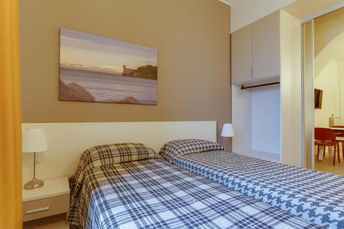 a bedroom with two beds and a painting on the wall at Residence Al Granzo in Trieste