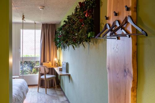 a room with a bedroom with a table and a desk at The Lab Experiments in Thun