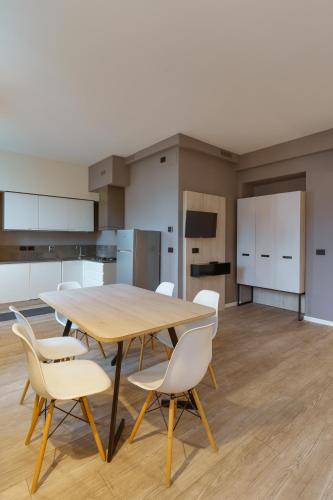 a kitchen with a wooden table and white chairs at Residence Al Granzo in Trieste