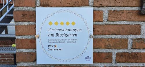 a sign hanging on a brick wall at Ferienwohnung am Bibelgarten Sophia in Werlte