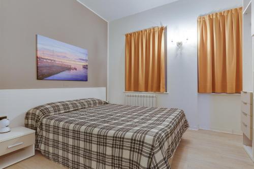 a bedroom with a bed with a plaid blanket at Residence Al Granzo in Trieste