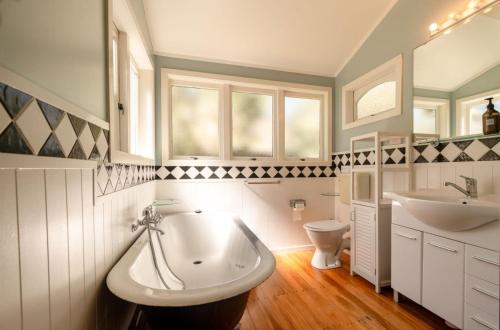 Waiheke IslandにあるTaimana Beach Front, Surfdaleの浴槽、洗面台、トイレを備えたバスルーム