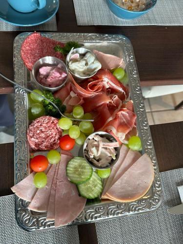 a tray of food with meat and vegetables on a table at Zeitlos Hotel Garni in Scharbeutz
