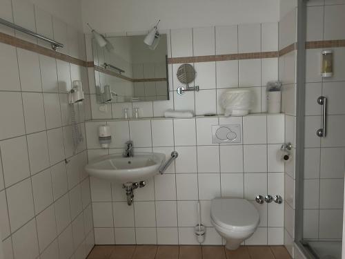 a bathroom with a toilet and a sink at Zeitlos Hotel Garni in Scharbeutz