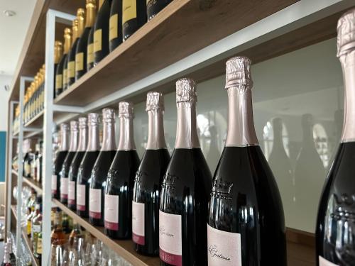 a row of bottles of wine on a shelf at Zeitlos Hotel Garni in Scharbeutz