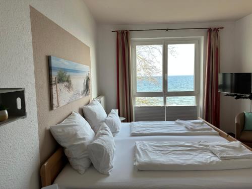 a hotel room with two beds and a window at Zeitlos Hotel Garni in Scharbeutz