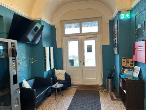 a living room with blue walls and a door at Zeitlos Hotel Garni in Scharbeutz