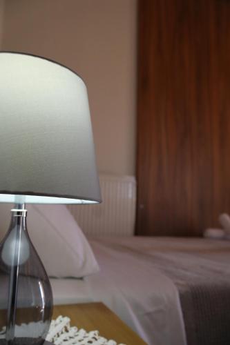a lamp sitting on a table next to a bed at Bujtina ANLU in Gjirokastër