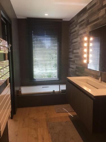 une salle de bain avec une baignoire, un lavabo et une fenêtre dans l'établissement House with pool, à Marseille