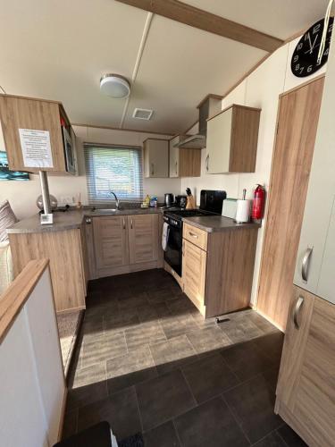 a kitchen with wooden cabinets and a stove top oven at Uisge Beatha in Dornoch