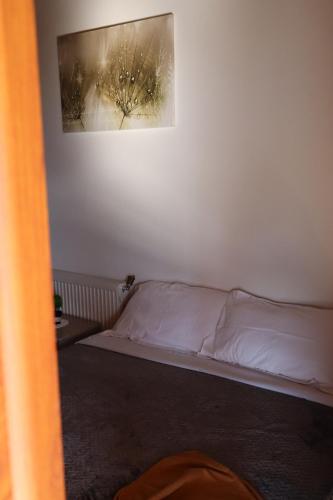 a bed in a room with a picture on the wall at Bujtina ANLU in Gjirokastër