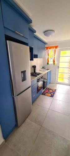 a kitchen with blue cabinets and a stainless steel refrigerator at Westbrook Blue Largo 33 in Westbrook