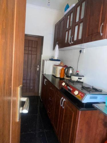 Una cocina con gabinetes de madera y un horno de estufa. en Home away from home, en Moshi