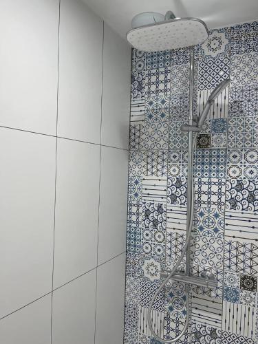 une douche dans une salle de bain avec un mur carrelé dans l'établissement Au Bon pied Bonneuil, à Bonneuil-les-Eaux