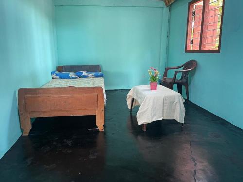 a blue room with a bed and a table with a table sidx sidx at Thapovanam in Allaippiddi