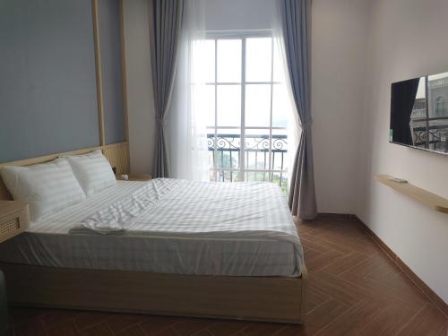 a bedroom with a large bed with a window at Sun Bay Hotel Phu Quoc in Phu Quoc