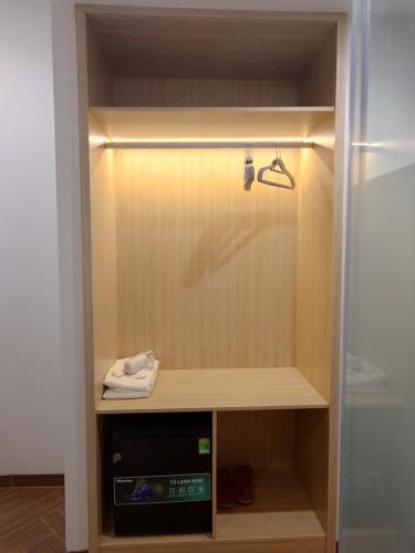 a closet with a wooden cabinet with a towel at Sun Bay Hotel Phu Quoc in Phu Quoc