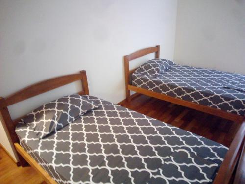 two beds sitting next to each other in a room at Costa Lodges, Funchal or Santa Cruz Madeira, shared room in Santa Cruz