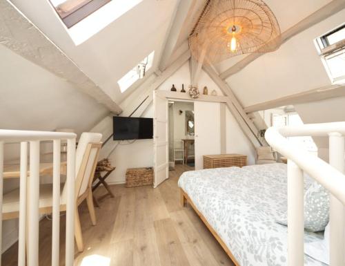 - une chambre mansardée avec un lit et une télévision dans l'établissement Gîte 4 étoiles au calme à proximité de la plage, à Saint-Valery-en-Caux