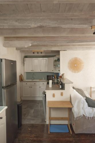 une cuisine avec un réfrigérateur et une table à l'intérieur dans l'établissement Gîte 4 étoiles au calme à proximité de la plage, à Saint-Valery-en-Caux