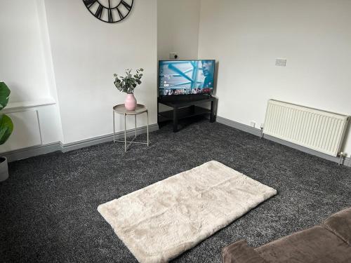 a living room with a couch and a tv at Spacious Apartment near train station with a parking space in Birmingham