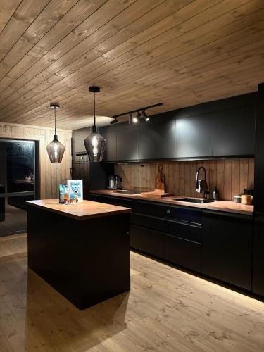 a kitchen with black cabinets and a kitchen island at Lyngen Vista - Arctic Luxury in Hamnnes