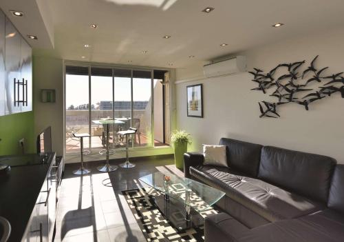 un salon avec un canapé et une table dans l'établissement Appartement Luxe - 4 personnes PETROUCHKA - Héliopolis J 41 -, au Cap d'Agde