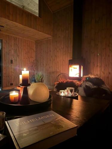 a room with two candles and a table with a book at Lyngen Vista - Arctic Luxury in Hamnnes