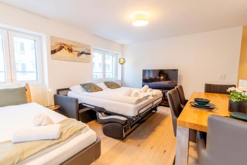 a room with two beds and a table and a dining room at Jasminkas Host 1, Ruhig, Gratis Parkplatz Balkon & im 1, Stockwerk in St. Gallen