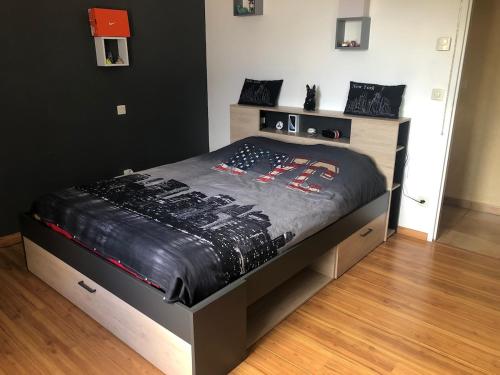 - un lit avec une couette noire dans une chambre dans l'établissement Maison au cœur du Périgord, à Saint-Vincent-le-Paluel