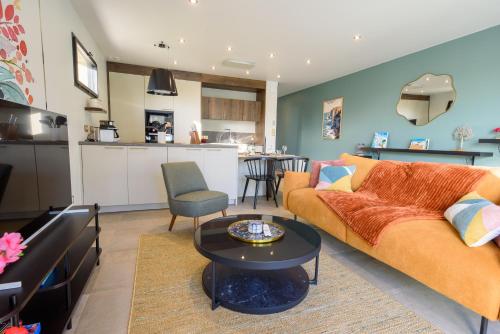 un salon avec un canapé et une table dans l'établissement Les Gîtes du Verger D'Albâtre, au Tilleul