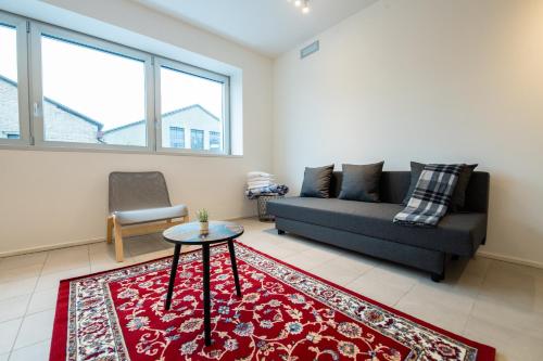 a living room with a couch and a table at Loft zona Stazione Centro con Wi Fi, Cucina & Parking Free in Parma