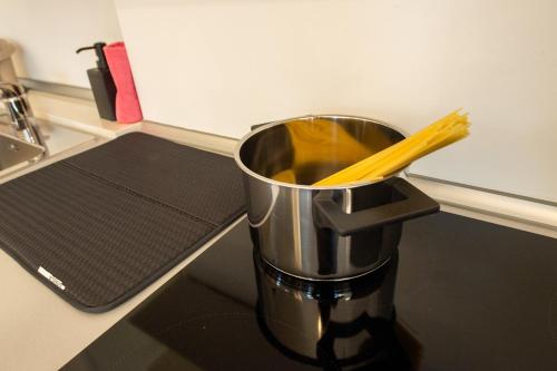 a metal bucket with a pair of chopsticks in it at Loft zona Stazione Centro con Wi Fi, Cucina & Parking Free in Parma