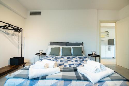 a bedroom with a large bed with towels on it at Loft zona Stazione Centro con Wi Fi, Cucina & Parking Free in Parma