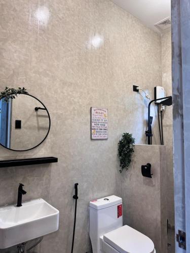 a bathroom with a white toilet and a sink at Pio Transient House in Tanay