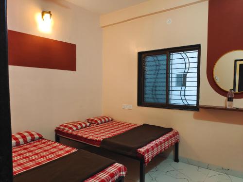 Una cama o camas en una habitación de Aaisaheb Bhakt Niwas