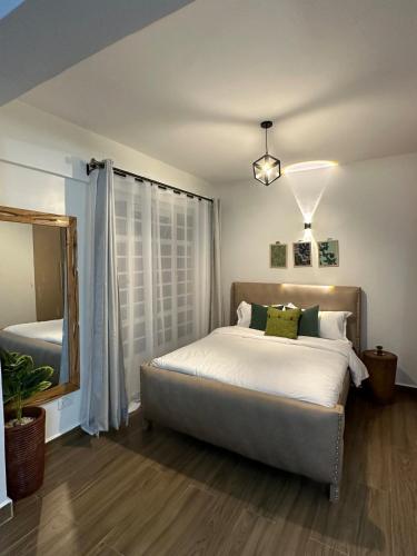 a bedroom with a large bed and a mirror at Spacious studio Ruaka in Ruaka