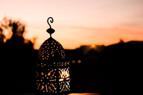 a lantern with the sunset in the background at Paradise Luxury Camp in Merzouga