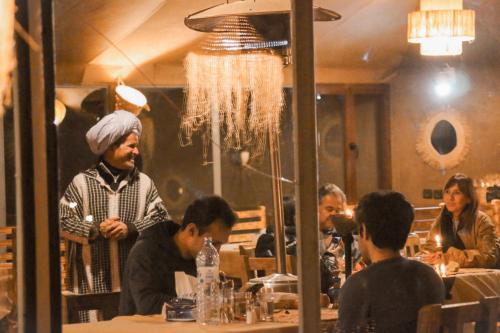 a group of people sitting at a table in a restaurant at Paradise Luxury Camp in Merzouga