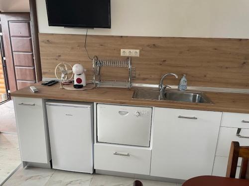 a kitchen with white cabinets and a sink at Вили Панорама 2 in Chernomorets