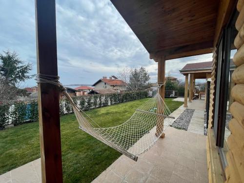 a hammock on a porch of a house at Вили Панорама 2 in Chernomorets