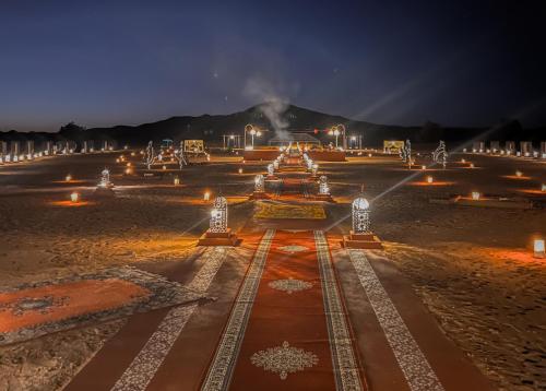 a park at night with lights on the ground at Paradise Luxury Camp in Merzouga