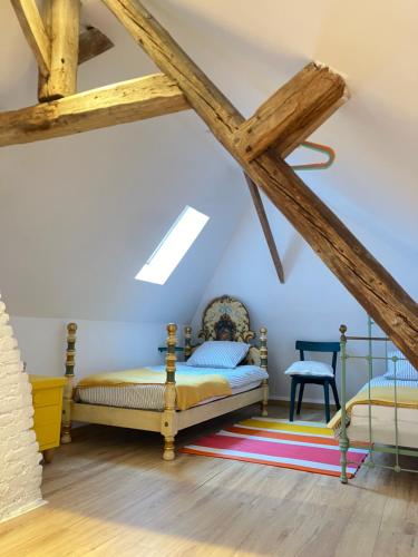 une chambre avec deux lits dans un grenier dans l'établissement Le Gîte de la Tannerye, au Tilleul