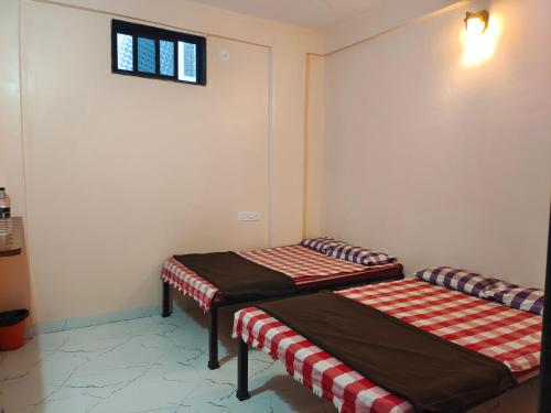 Una cama o camas en una habitación de Aaisaheb Bhakt Niwas