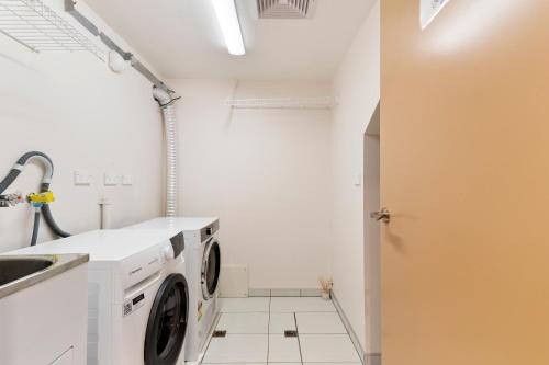 a laundry room with a washing machine and a sink at Closeburn LakeView House in Queenstown
