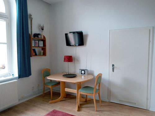 Zimmer mit einem Tisch und Stühlen sowie einem TV an der Wand in der Unterkunft FeWo Radau in Bad Harzburg