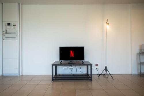 a television sitting on a table in a room at Loft zona Stazione Centro con Wi Fi, Cucina & Parking Free in Parma