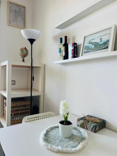 a white table with a lamp and a vase on it at Sky Penthouse at Rome Fiumicino Airport in Fiumicino