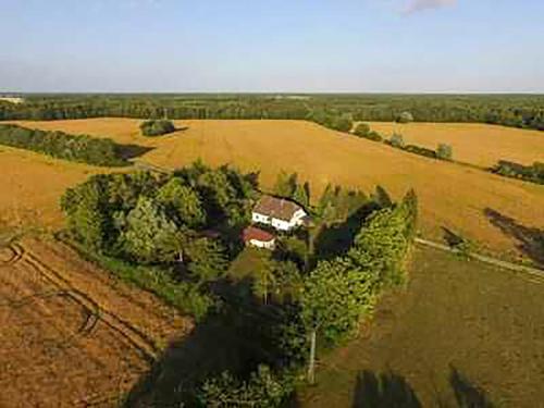 une vue aérienne d'une maison au milieu d'un champ dans l'établissement Ferienwohnungen am Waldrand, à Ahrenshagen