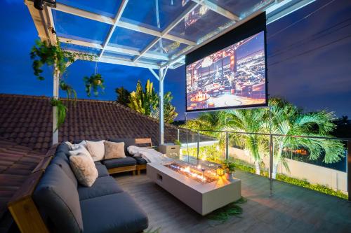 a living room with a couch and a large screen at Kira Japandi Escape with Sauna & Rooftop cinema in Hua Hin